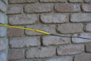 Connection to the end of the antenna wire is by opening the end of the cord tube, inserting the wire and then using Araldite or similar to glue them together. Heatshrink finishes it off neatly.