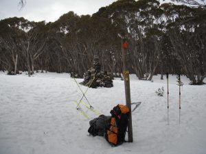 The summit cairn with packs and skis
